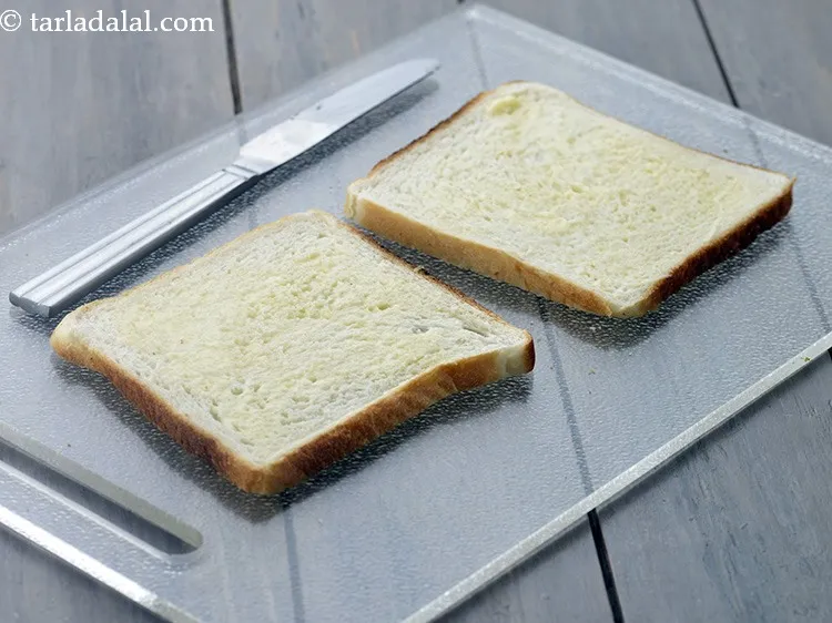 Step 12 – Apply &frac12; tsp of <a href="https://www.tarladalal.com/glossary-butter-makhan-233i">butter</a>&nbsp;on each bread slice.