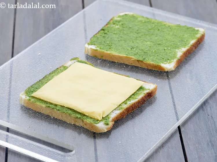 Step 14 – Place a <a href="https://www.tarladalal.com/glossary-cheese-slices-765i">cheese slice</a>&nbsp;over one buttered-chutney bread slice.