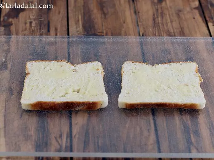 स्टेप 16 – प्रत्येक ब्रेड स्लाइस पर १/२ टीस्पून मक्खन फैलाएं और समान …