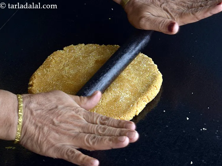 Step 12 – Roll the <strong>kopra chikki with jaggery</strong> using a greased rolling pin to make 325 mm. …