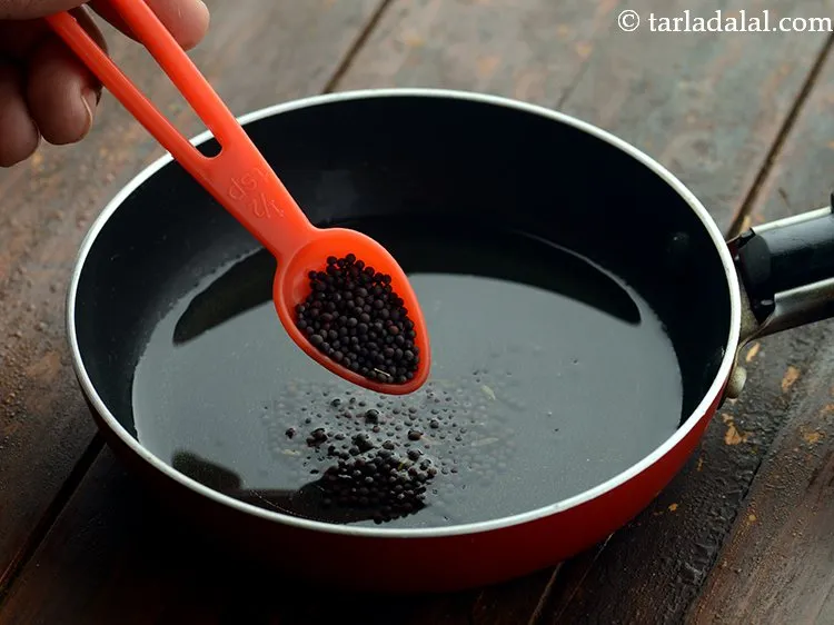 Step 13 – Once the ghee is hot, add the mustard seeds.