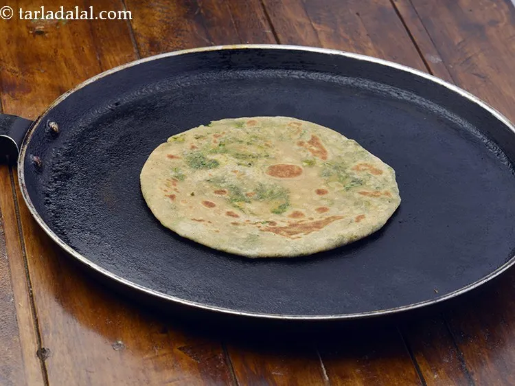 Step 23 – Heat a non-stick tava (griddle) and cook the <strong>hara dhania roti</strong>, using a little oil, …