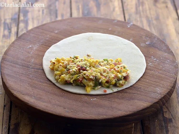 Step 19 – Place a portion of the stuffing on one half of the tortilla.&nbsp;Spread it evenly.