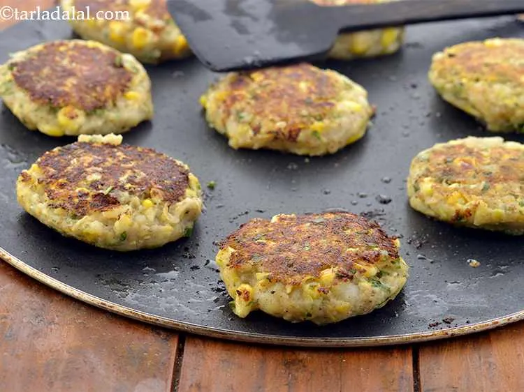 Step 32 – Gently slide a flat spoon and check if the&nbsp;corn tikkis&nbsp;are golden brown and cooked on …
