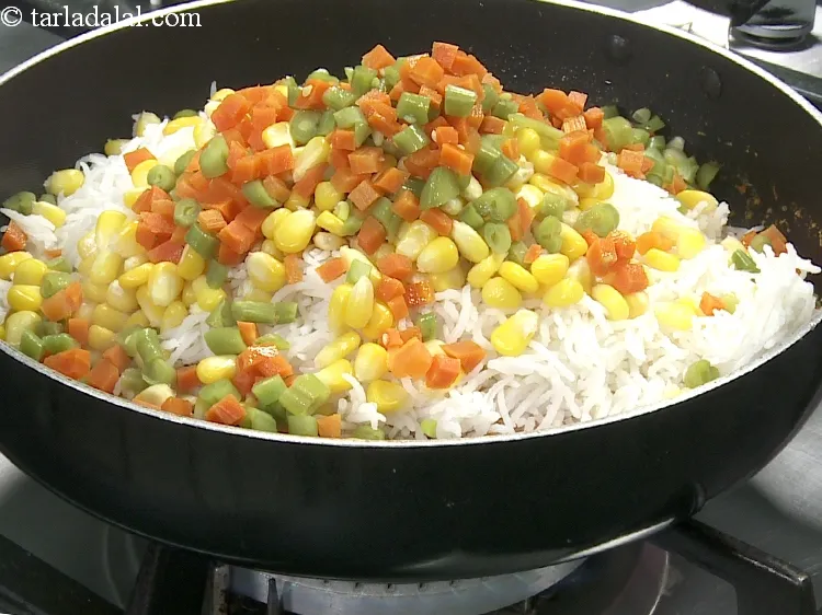 Step 33 – Add 3/4 cup&nbsp;<a href="https://www.tarladalal.com/glossary-chopped-and-boiled-mixed-vegetables-1884i">chopped and boiled mixed vegetables</a>&nbsp;(carrots and french beans).