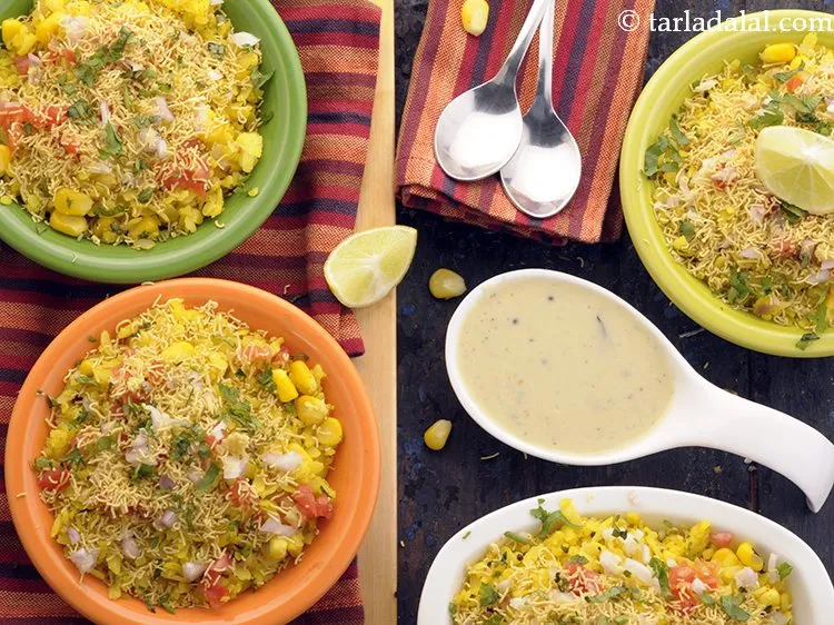 Step 18 – Serve <strong>corn poha</strong> hot topped with tomatoes, onions, sev and a lemon wedge.