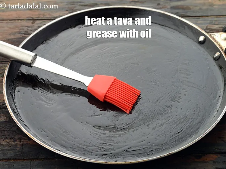 Step 22 – Heat a non-stick tava (griddle) and lightly grease it 2 tsp <a href="https://www.tarladalal.com/glossary-oil-671i">oil</a>. &nbsp;