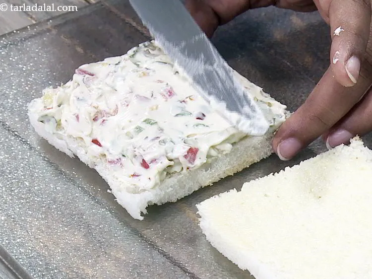 Step 13 – Put a portion of the prepared filling on a buttered bread slice and spread it …