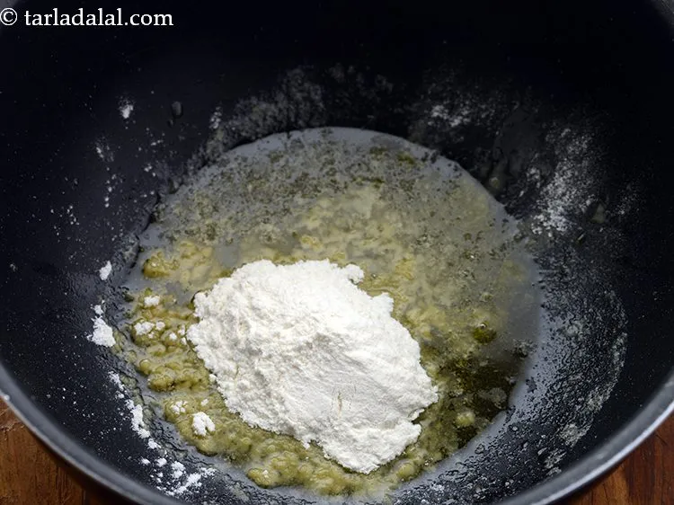Step 12 – Add plain flour which will help in adding thickness to our <strong>cream of broccoli soup</strong>.&nbsp;