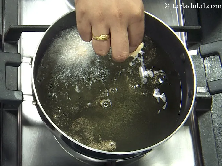 Step 18 – For frying the<strong> Indian style fried cauliflower</strong>, heat the oil in a kadhai and drop …