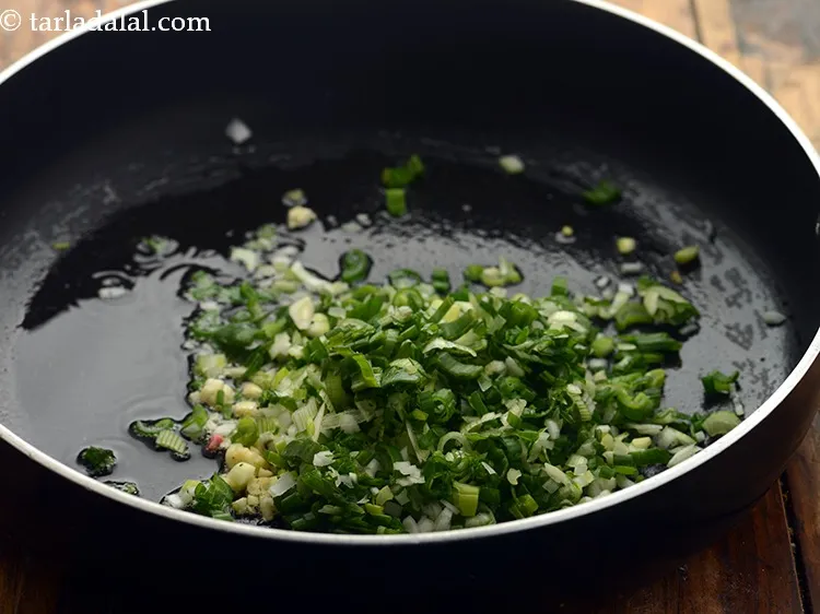 Step 26 – Add 1/4 cup&nbsp;finely&nbsp;<a href="https://www.tarladalal.com/glossary-chopped-spring-onions-1575i">chopped spring onions</a>&nbsp;(whites and greens).