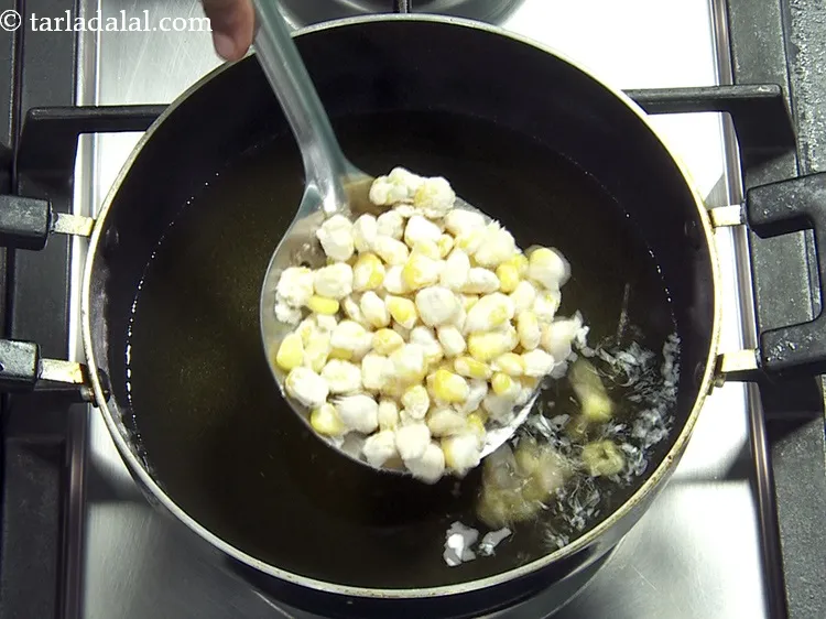 Step 16 – Using a slotted spoon, add some corn mixture in the hot oil.&nbsp;