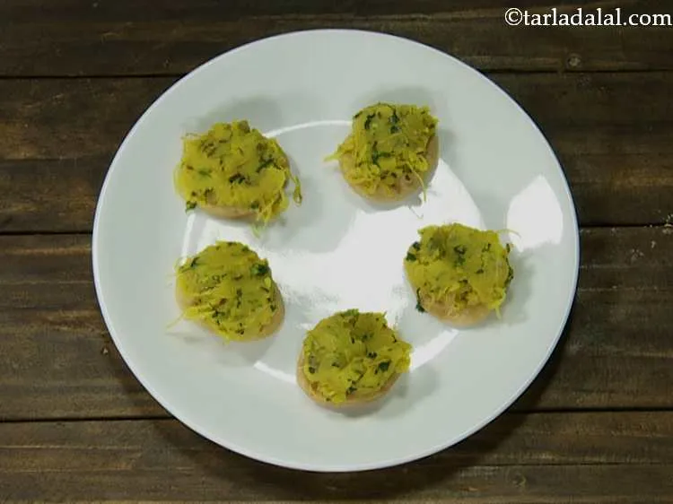 स्टेप 13 – प्रत्येक पुरी के ऊपर एक चम्मच आलू का मिश्रण रखें …