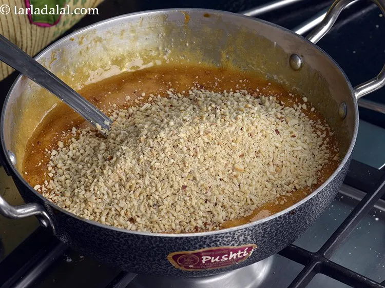 स्टेप 10 – भूनी और क्रश की हुई मूंगफली डालें।