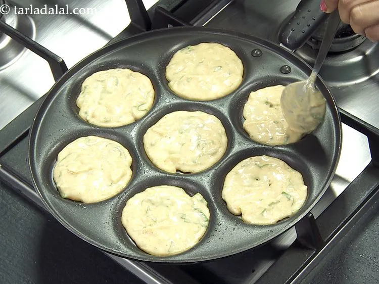 Step 13 – Pour a spoonful of the batter into each uttapa mould and spread it evenly.