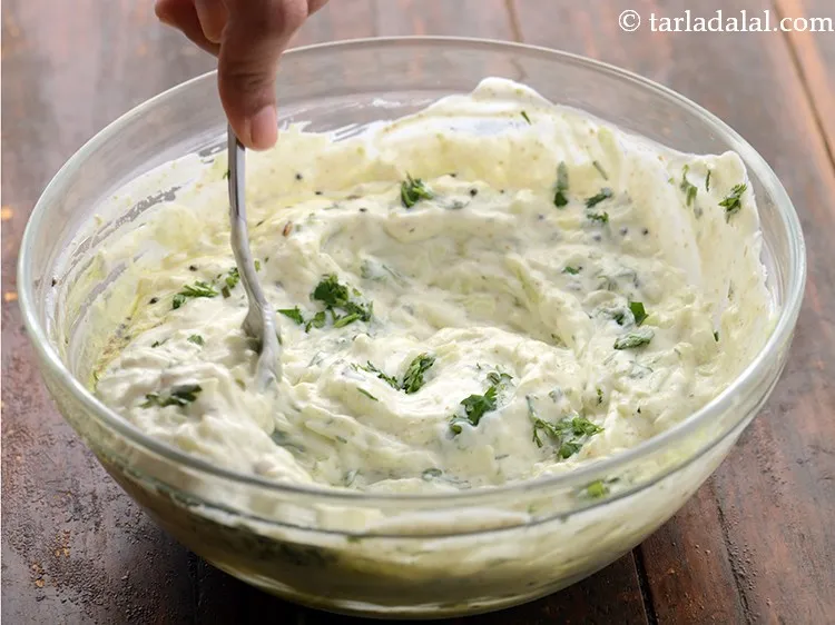 स्टेप 17 – खीरे के रायते को अच्छे से मिलाएं।