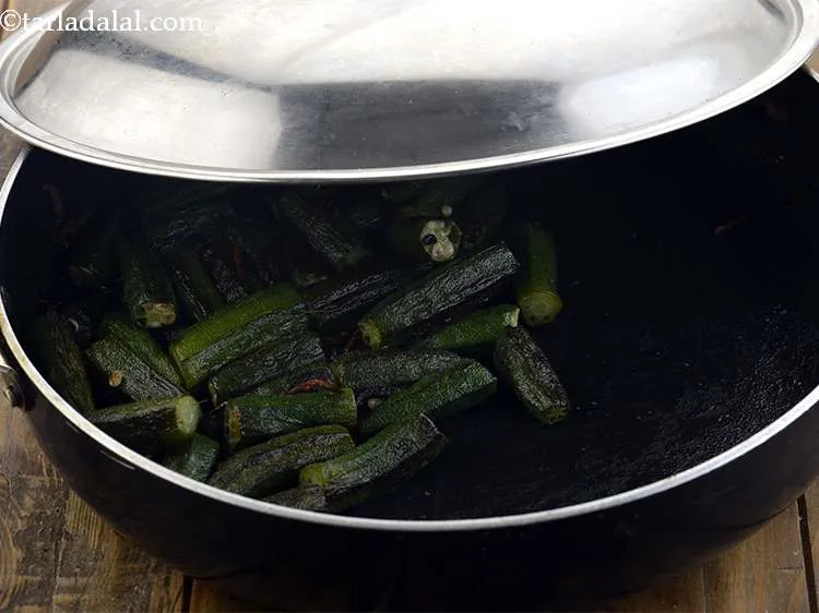 Step 7 – Add the Bhindi, &frac12; a tsp of salt and 2 tsp of water to prevent …