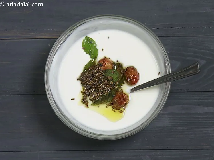 स्टेप 9 – इस तड़के को दही के मिश्रण के ऊपर डालें।