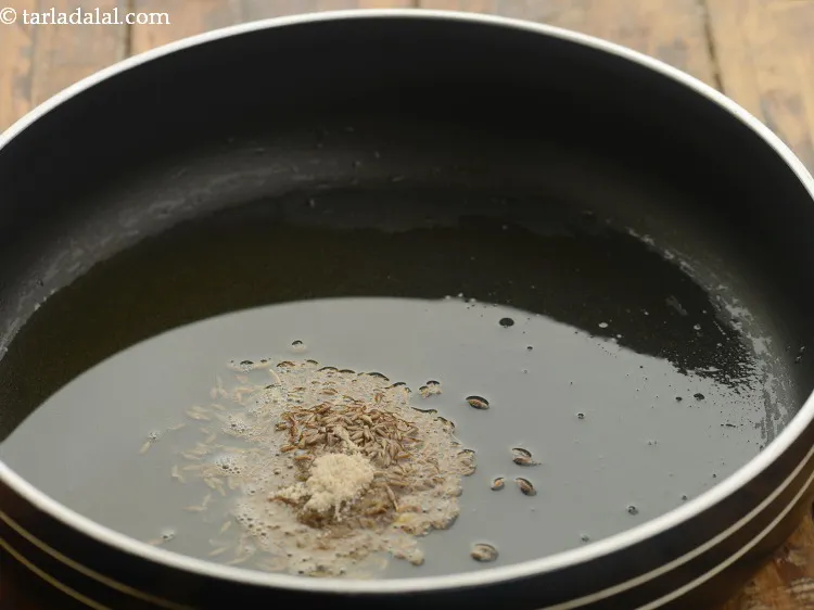 Step 17 – When the seeds crackle, add the asafoetida.