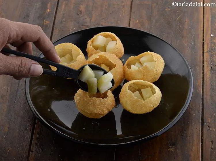 स्टेप 11 – १ टी-स्पून उबाले और कटे हुए आलू को प्रत्येक पूरी …