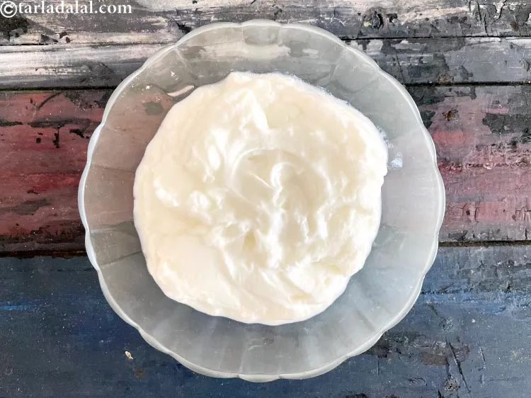 Step 25 – In a glass bowl, put&nbsp;<meta charset="UTF-8" />1 1/2 cups&nbsp;<a href="glossary-whisked-curds--2096i">whisked curds (dahi)</a>.