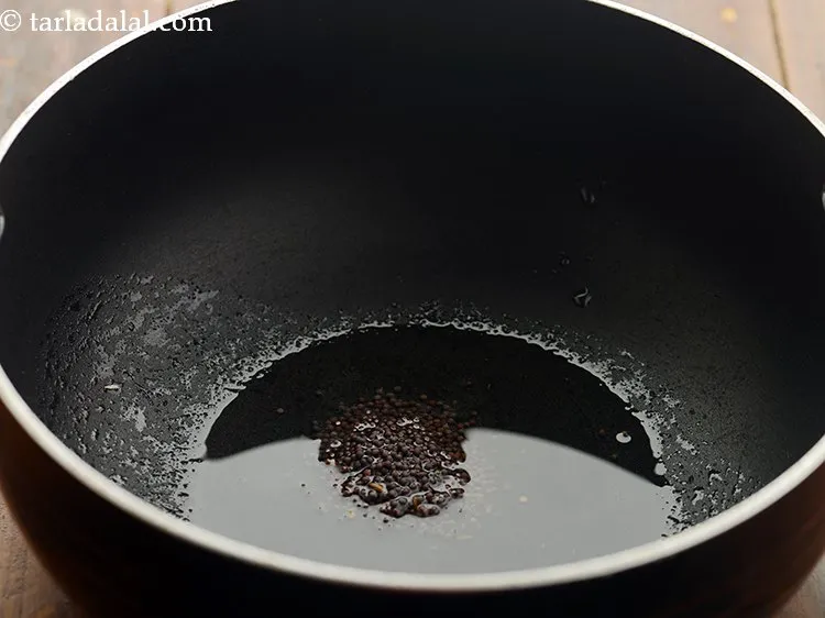 स्टेप 5 – तेल गरम होने के बाद इसमें सरसों डालें।