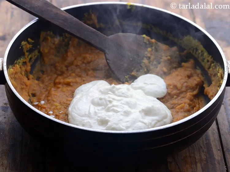 Step 23 – Lower the flame, add the curds-besan mixture. If you are a beginner, remove the pan …