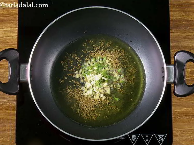 Step 14 – Furthermore, add green chillies and garlic. I love freshly pounding the condiments using a mortar …