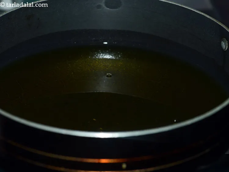 Step 10 – Heat the ghee in a deep non-stick kadhai and deep-fry 4 dough portions at a …