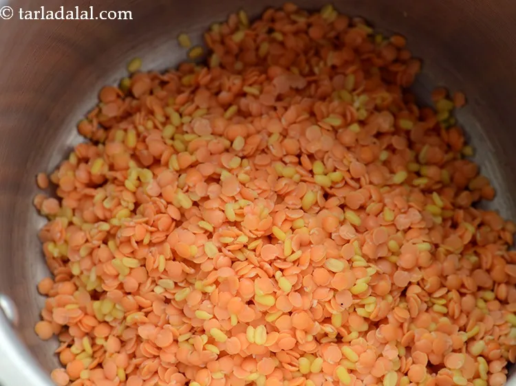स्टेप 4 – एक प्रेशर कुकर में भिगोए और छाने हुए दाल डालें। …
