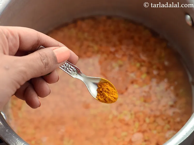 स्टेप 6 – हल्दी पाउडर डालें। <strong>दाल फ्राई</strong> को ज्यादा मसालेदार नहीं किया …