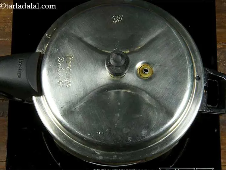 Step 4 – Close the lid and pressure cook for 3 whistles or till the dal is cooked.