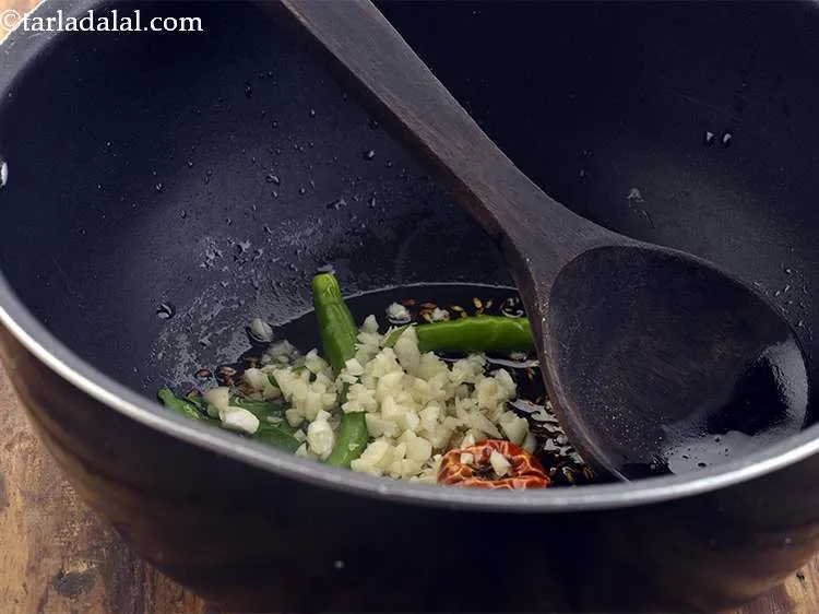 Step 23 – Also add the garlic.This will perk up the flavour of the <strong>Dal Khichdi</strong>.