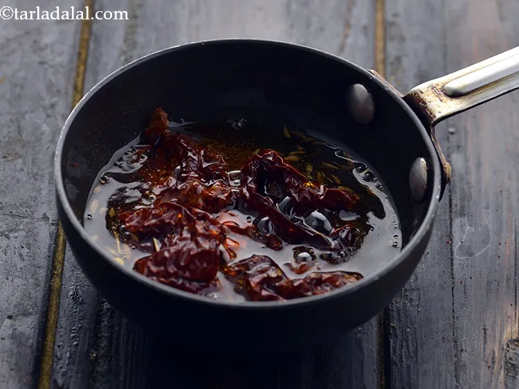 Step 31 – When the seeds crackle, add the red chilli.