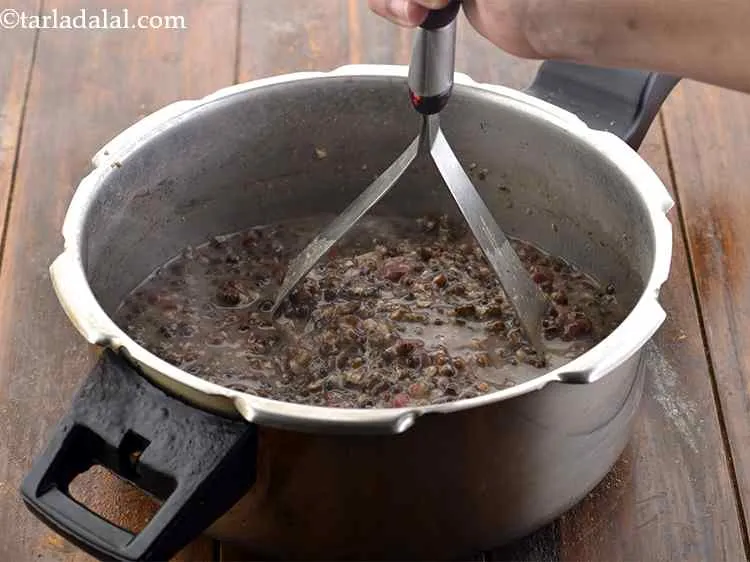 स्टेप 10 – दाल को मैश करे जब तक वो गल न जाए। …