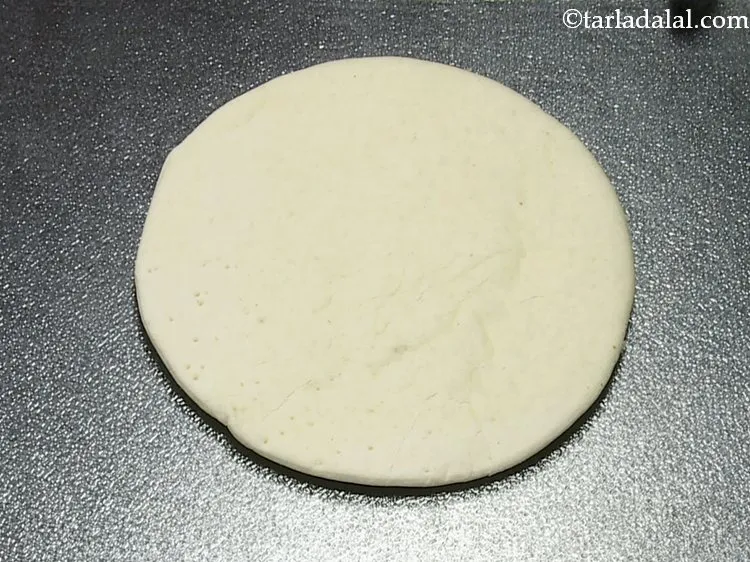 Step 13 – To prepare the double layered cheese veggie crunch pizza, place a pizza base on a …