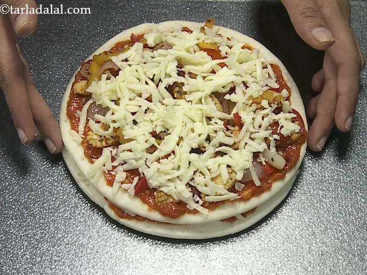 Step 19 – Finally again sprinkle &frac14; cup of mozzarella cheese evenly over it.
