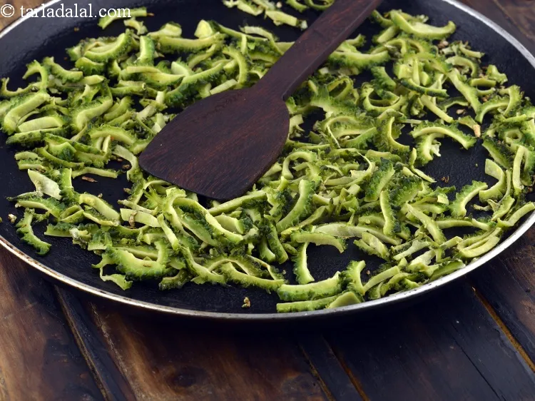 Step 28 – While cooking the karela slices on the tava, ensure to toss occasionally so the slices …
