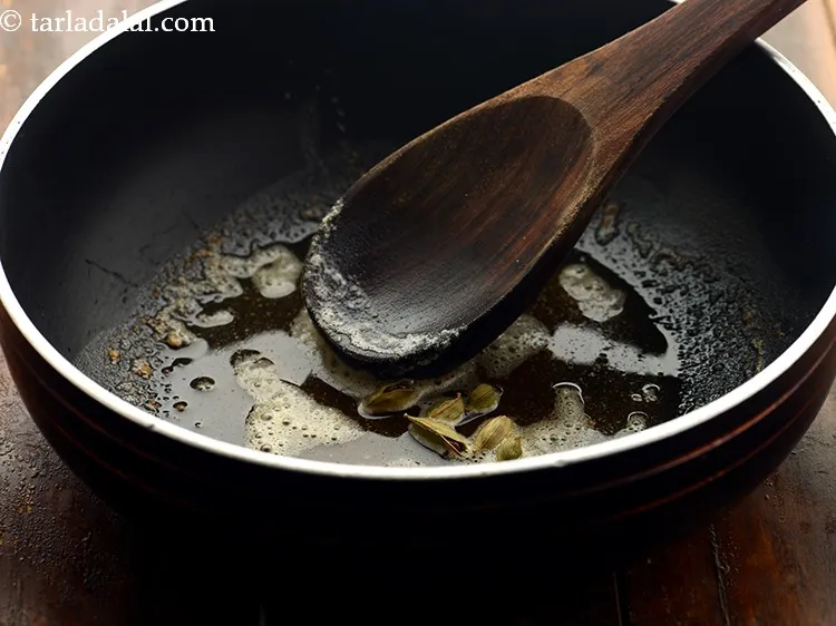 Step 19 – Once the oil is hot and butter is melted, add the cardamom. &nbsp;