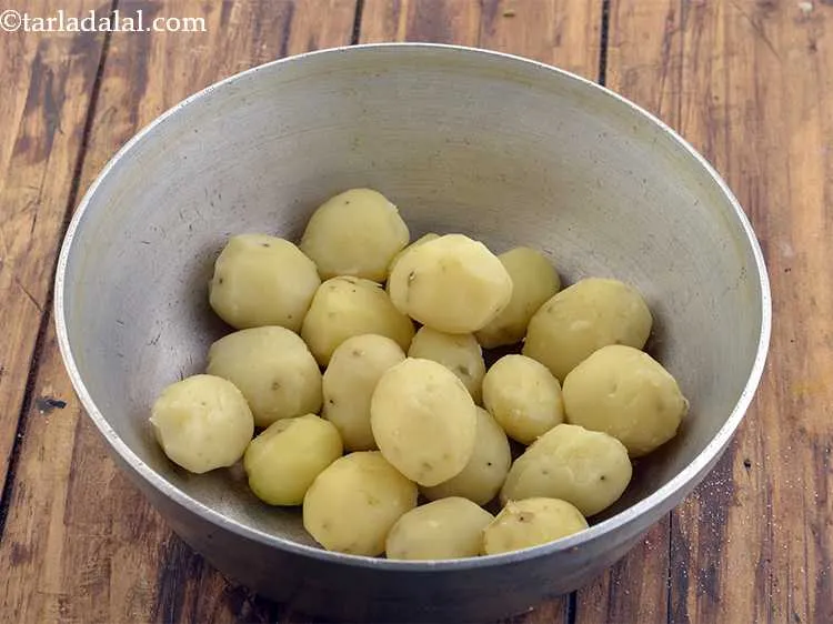 स्टेप 5 – पके हुए सारे छोटे आलू को छील लें और छिलकों …