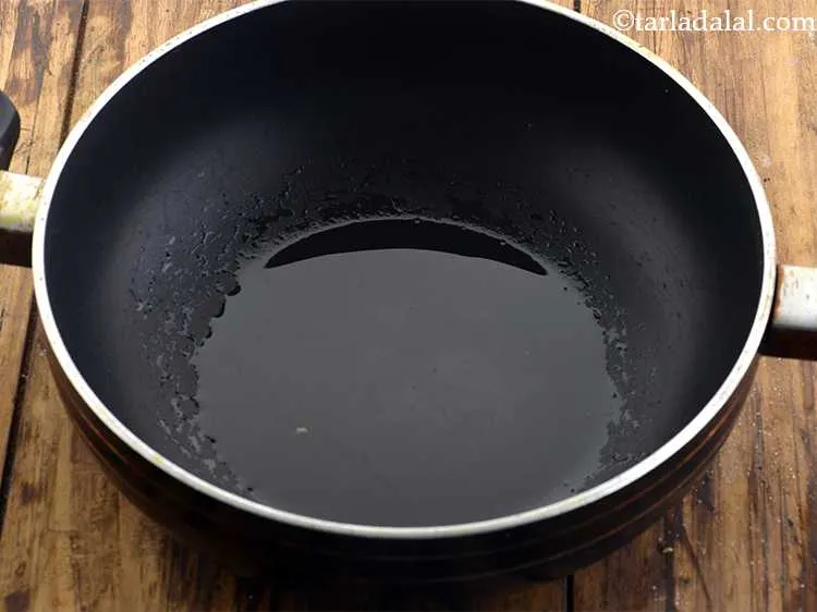 Step 20 – To prepare <strong>basic dum aloo gravy</strong>, heat the oil in a non-stick kadhai.&nbsp;