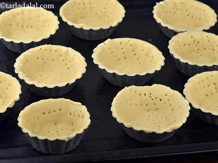Step 11 – Arrange the&nbsp;<strong>eggless tarts</strong>&nbsp;on a baking tray and bake in a pre-heated oven at 200&ordm; C …