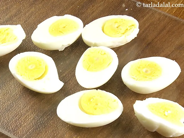 स्टेप 6 – प्रत्येक अंडे को लंबवत रूप से आधा काट लें। एक …