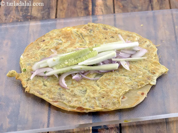 Step 29 – Spread &frac14;th of the onion mixture horizontally and spread 10 cucumber strips over it.