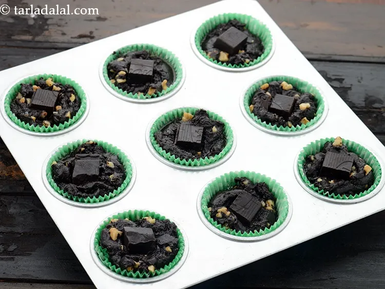 स्टेप 18 – प्रत्येक मफिन मोल्ड में १ चॉकलेट क्यूब डालें और हल्के …