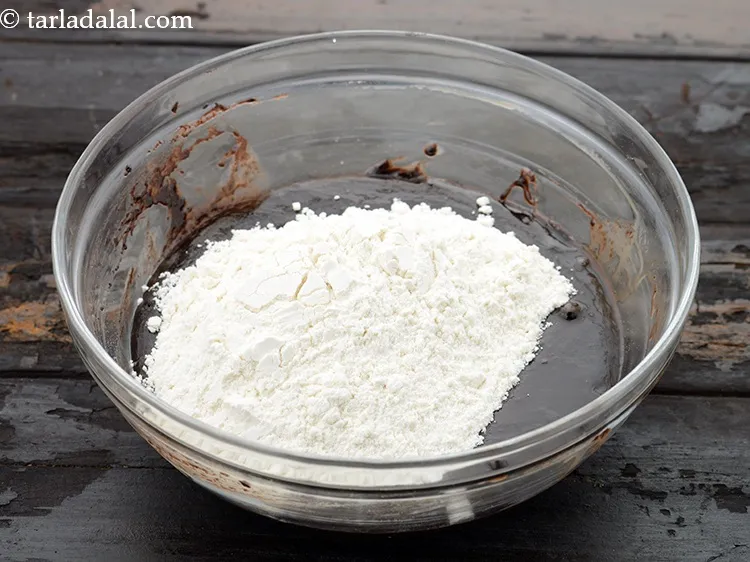 स्टेप 11 – ३/४ कप <a href=""https://www.tarladalal.com/glossary-plain-flour-maida-hindi-188i"">मैदा</a> डालें। यह गांठ रहित होना चाहिए।