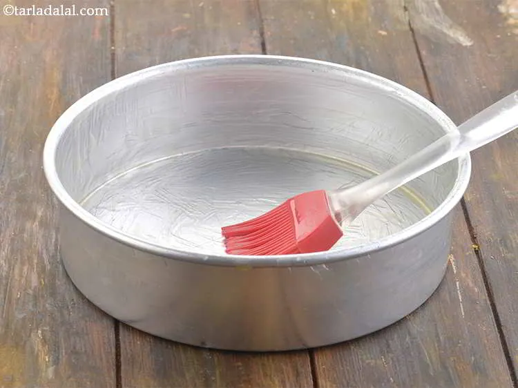 Step 21 – To prepare the cake tin for <strong>eggless chocolate cake in pressure cooker recipe | eggless …