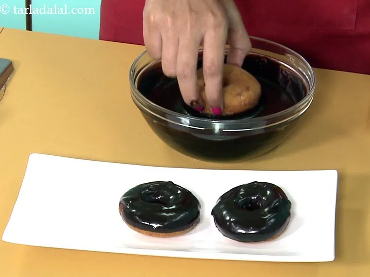 Step 45 – While the <strong>doughnuts </strong>are yet warm, dip one half of a doughnut in the dark …