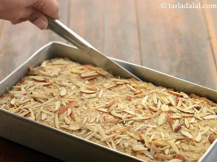 Step 28 – Cool the&nbsp;<strong>eggless date and almond cake</strong>&nbsp;slightly and loosen the sides of the cake using a …