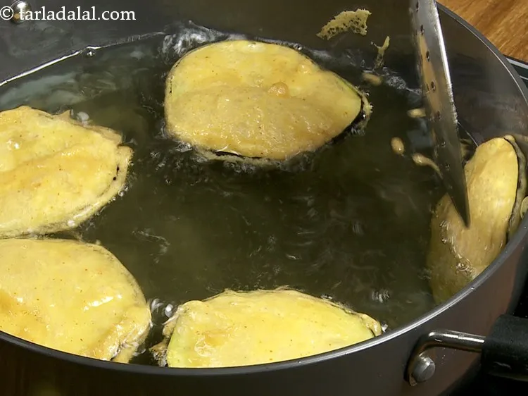 Step 13 – Flip and fry till the brinjal bhaji turn golden brown in colour from all the …